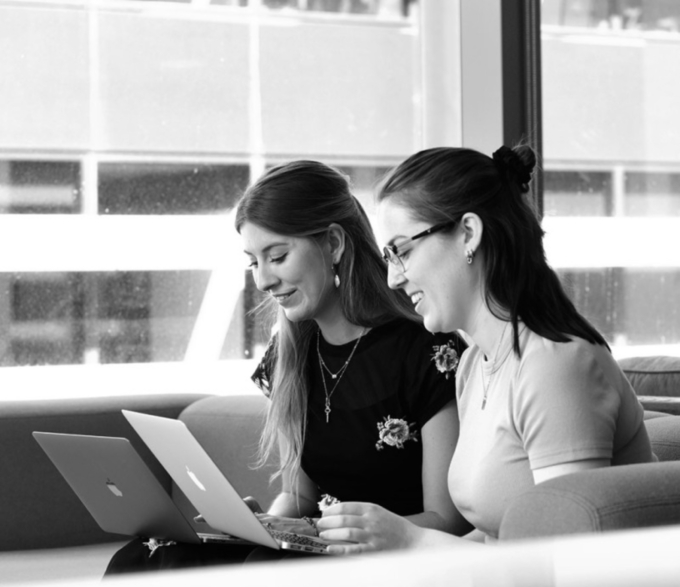 two women with laptops